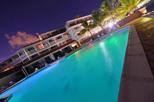 una grande piscina di fronte a un hotel di notte di Le Stanley Hôtel a Noumea