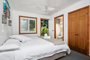 - une chambre avec un grand lit blanc et une fenêtre dans l'établissement Lorhiti Apartments, à Lord Howe