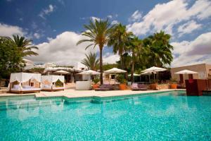 una gran piscina con sillas y sombrillas en Can Lluc Hotel Rural, en Sant Rafel de sa Creu