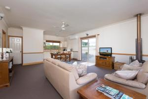 a living room with two couches and a tv at Windsors Edge Cottage Pokolbin in Rothbury