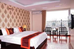 a bedroom with a large bed and a balcony at Mely Hotel Hà Nội in Hanoi
