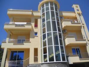 a large yellow building with a tall tower at Kopernikus Apartments in Ulcinj