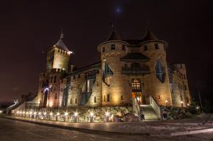 un castillo grande por la noche con luces encendidas en Nesselbeck, en Orlovka