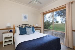 una camera da letto con un letto e una grande finestra di Windsors Edge Cottage Rothbury a Rothbury