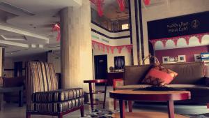 vestíbulo con sofá, mesa y sillas en Meral Hotel, en La Meca