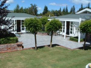 two trees in a yard in front of a house at Cheltenham House in Hanmer Springs