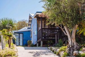 una casa azul con un árbol delante en The Blue Beach House, en Quinns Rocks