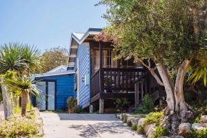 a blue house with a tree in front of it at The Blue Beach House in Quinns Rocks