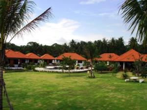 a resort yard with houses and palm trees at Sailom Resort Bangsaphan in Bang Saphan