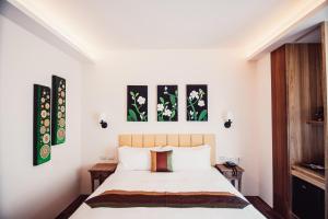 una camera da letto con un letto e tre dipinti alle pareti di Dreamer Boutique Hotel a Nanwan