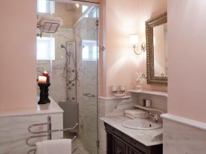 a bathroom with a shower and a sink and a mirror at Hotel Ploes in Ermoupoli