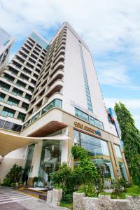 a large white building with glass windows at Gold Orchid Bangkok Hotel in Bangkok