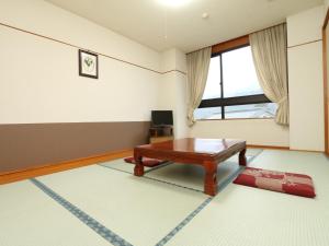 a living room with a table and a window at Oze Shinkousou in Katashina