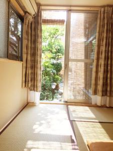 an empty room with a large window with curtains at Guesthouse Kyoto Kaikonoyashiro in Kyoto