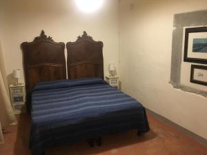 a bedroom with a bed with a blue blanket at La Guardia B&B in Stia