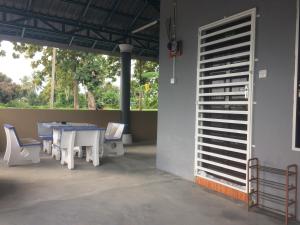 a patio with a table and chairs next to a wall at Roomstay Zulmi in Arau