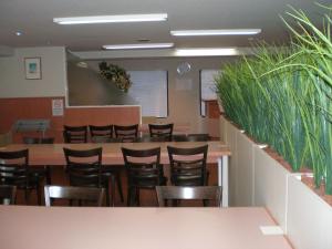a dining room with chairs and tables and plants at Takasaki Ekimae Plaza Hotel in Takasaki