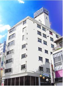 a white building with a clock tower on top of it at Takasaki Ekimae Plaza Hotel in Takasaki