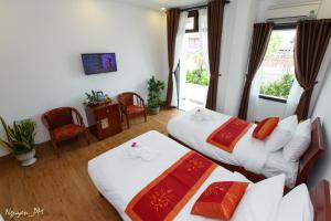 a hotel room with two beds and a window at Gia Lam Villa Hoi An in Hoi An