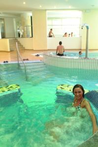 a woman laying in a swimming pool at Good Life Hotel Zirm in Obereggen