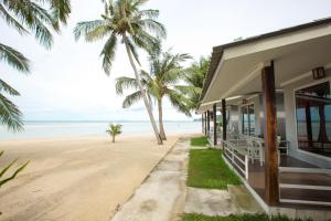 a house on the beach with palm trees at Da Kanda Villa Beach Resort in Thong Sala