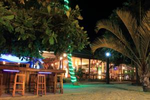 a bar with stools and a tree in front of a building at Da Kanda Villa Beach Resort in Thong Sala