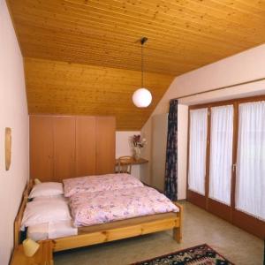 1 dormitorio con cama y techo de madera en Ristorante Alpino en Sonogno