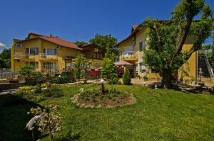 a yard with a garden in front of two buildings at Iskar Villas in Kranevo