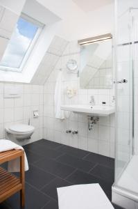 a bathroom with a shower and a sink and a toilet at Parkhotel Lippstadt in Lippstadt