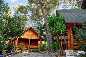 a log cabin with a tree in front of it at Balneario San Andres in Canena
