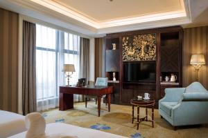Habitación de hotel con cama, escritorio y TV. en Chengdu Jin Yun Hotel en Chengdú