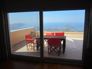 a table and chairs on a balcony with a view of the ocean at Viva B&B in Anavyssos