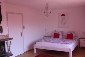 a bedroom with a bed with red pillows on it at Lila Villa Schwenningen in Villingen-Schwenningen