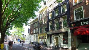 une rue avec des bâtiments et des gens qui marchent dans la rue dans l'établissement The Bolster, à Amsterdam