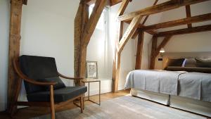 1 dormitorio con silla junto a la cama en The Bolster, en Ámsterdam