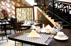 a dining room with a table with plates and wine glasses at Mel's Inn Manado in Manado