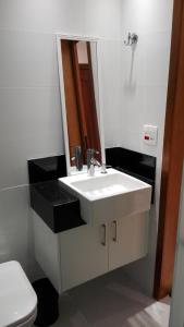 y baño con lavabo blanco y espejo. en Flat Ricamar, en Río de Janeiro