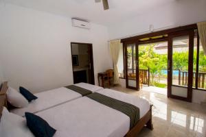 una camera da letto con un letto grande e un balcone di Pantai Bungalow Lembongan Island a Nusa Lembongan Altre 113 foto