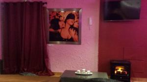 una sala de estar con chimenea y una foto en la pared en Apartamentos Luxury Ciempozuelos, en Ciempozuelos