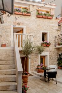 a stone building with stairs and potted plants at Stone house luxury rooms in Split