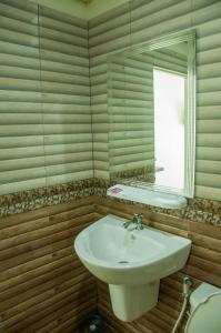 La salle de bains est pourvue d'un lavabo, d'un miroir et de toilettes. dans l'établissement Pleai Ta Lea Resort, à Chao Lao Beach