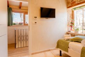 a small room with a bed and a flat screen tv at Stone house luxury rooms in Split