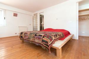 een slaapkamer met een bed en een houten vloer bij Loft in Authentic Rome Hood in Rome