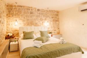 a bedroom with a large bed with towels on it at Stone house luxury rooms in Split