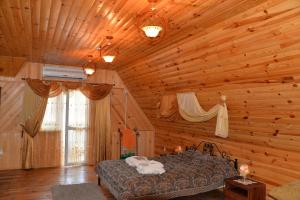 a bedroom with a bed in a log cabin at Galicky Dvir Hotel in Svityazʼ