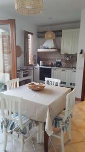 a kitchen with a white table with chairs and a table at Il Dolce Risveglio Tanca Piras in Nebida