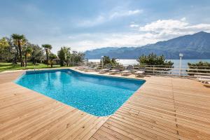 a swimming pool with chairs and a view of the water at Residence Parco Lago di Garda in Malcesine