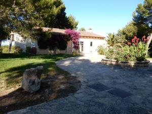a house with a stone walkway in front of a yard at Finca En Sueno de Son Jaumell in Cala Ratjada