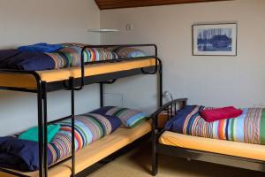 a room with two bunk beds with colorful pillows at Private Island De Sayter in Warten