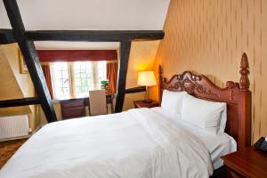 sypialnia z dużym białym łóżkiem i oknem w obiekcie Cromwell Lodge Hotel by Greene King Inns w mieście Banbury